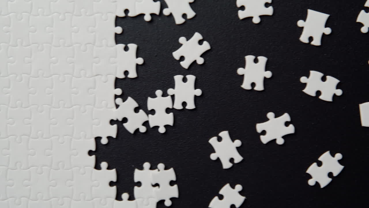 White puzzle elements assembled on black background indoor closeup top view