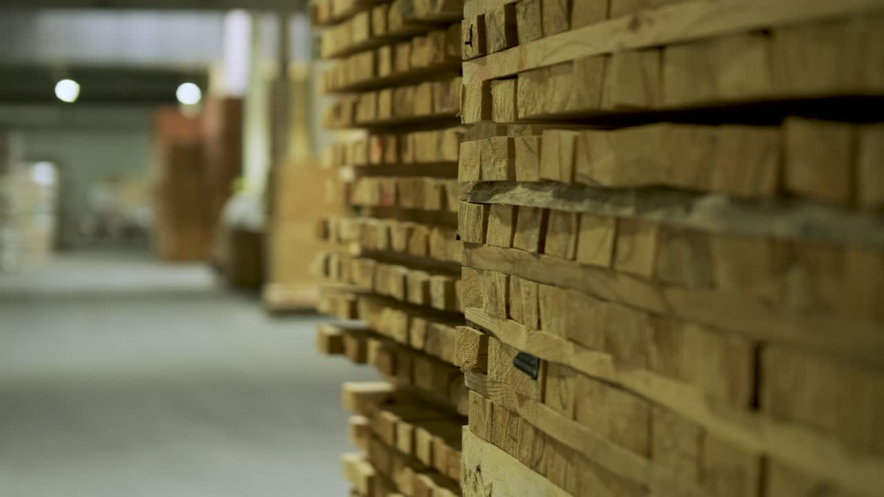 Cataste di assi di legno immagazzinate in un magazzino industriale.