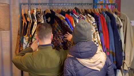 customers are browsing through clothes at an antique store