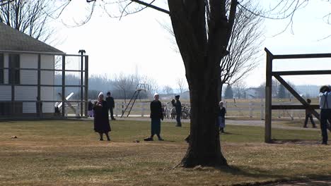 a group of amish young people are playing games outdoors