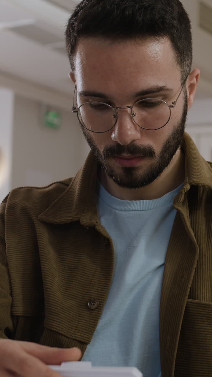A man with a beard and glasses indoors