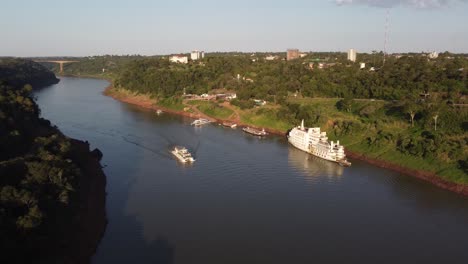 tourist boat on iguazu river during sunset time - border between argentina and brazil - drone shot