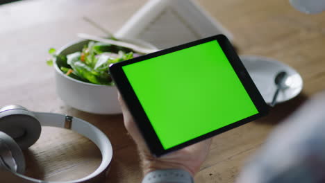 hombre de negocios usando una tableta en una cafetería viendo la pantalla verde en un dispositivo móvil clave de croma disfrutando del entretenimiento en línea bebiendo café leyendo publicidad en redes sociales de cerca manos