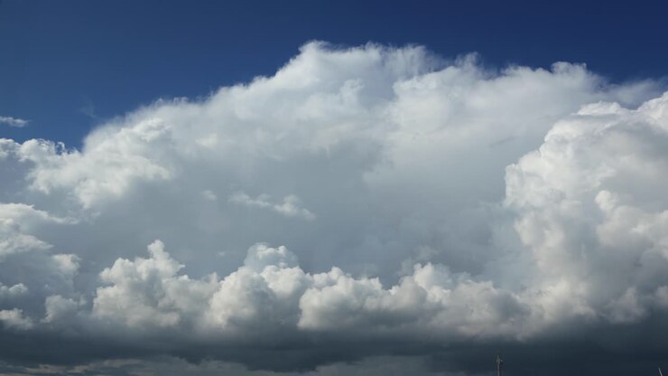 Growing and swelling dramatic slow cumulus cloud formation time lapse passing by with percipitation