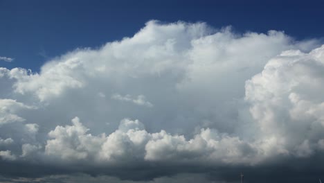 growing and swelling dramatic slow cumulus cloud formation time lapse passing by with percipitation