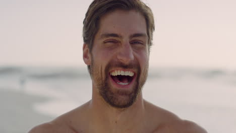 close up portrait of muscular young man laughing cheerful enjoying healthy lifestyle on beautiful seaside beach real people series