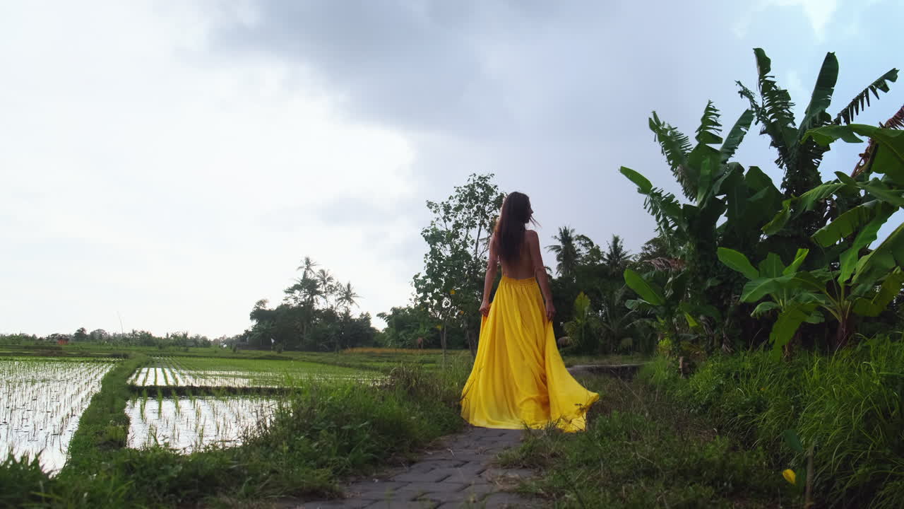Donna in abito giallo in una risaia a Bali