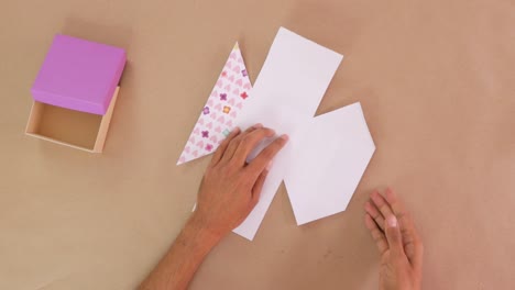 making wrapping for cardboard gift box from decorative paper with glue