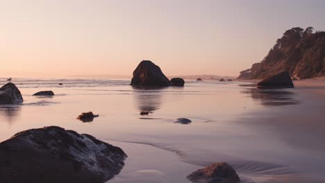 encantadora playa con rocas y colorida luz del sol desde el amanecer