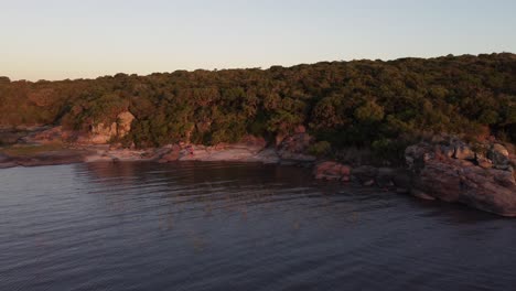 People-relaxing-on-lakeshore-of-Laguna-Negra-at-sunset,-Uruguay