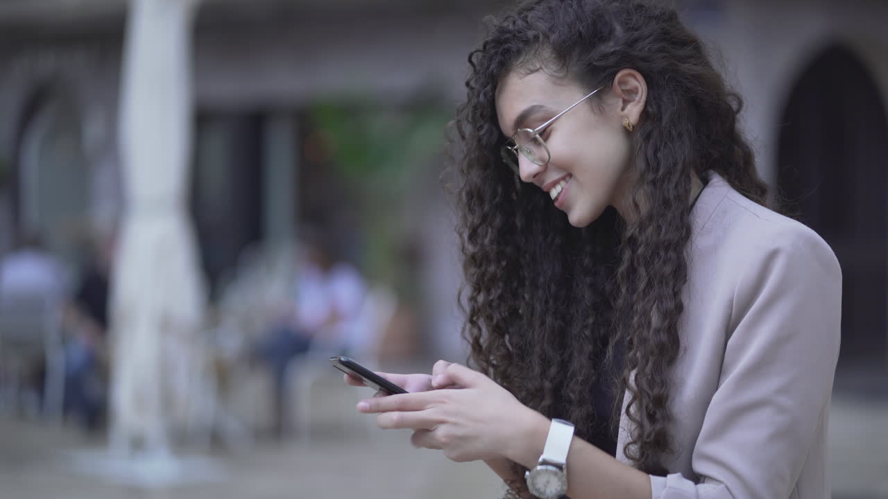 Mujer joven usando un teléfono inteligente al aire libre