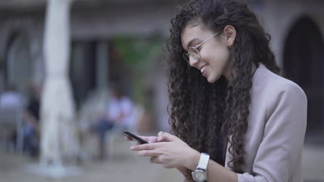mujer joven usando teléfono inteligente al aire libre