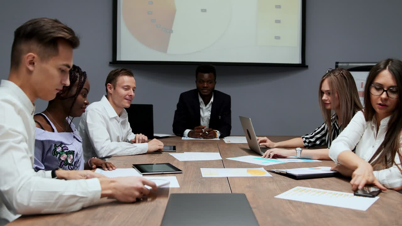 크리에이티브 다민족 매니저 그룹은 컨퍼런스 홀에서 이사회 회의에서 회사에서 지난 1 년 동안의 수익 그래프를 해체합니다.