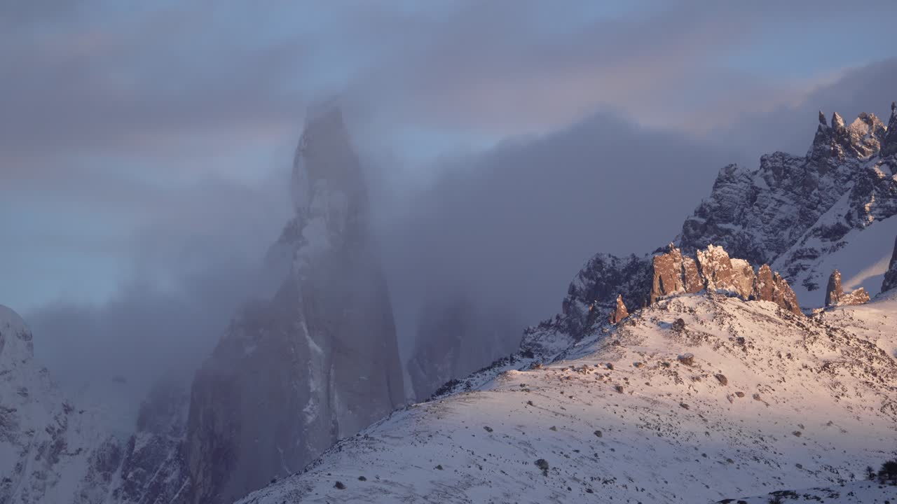 cerro torre pico cubierto de nieve con nubes girando en un lapso de tiempo al amanecer en la patagonia