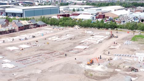 UK-town-residential-housing-development-working-foundation-construction-site-aerial-view-orbit-right