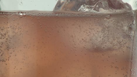 cerca de limonada rosa o agua de rosas llenando un vaso con hielo