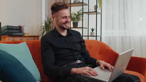 Guy-sitting-on-home-couch,-looking-at-camera,-making-video-conference-call-with-friends-or-family