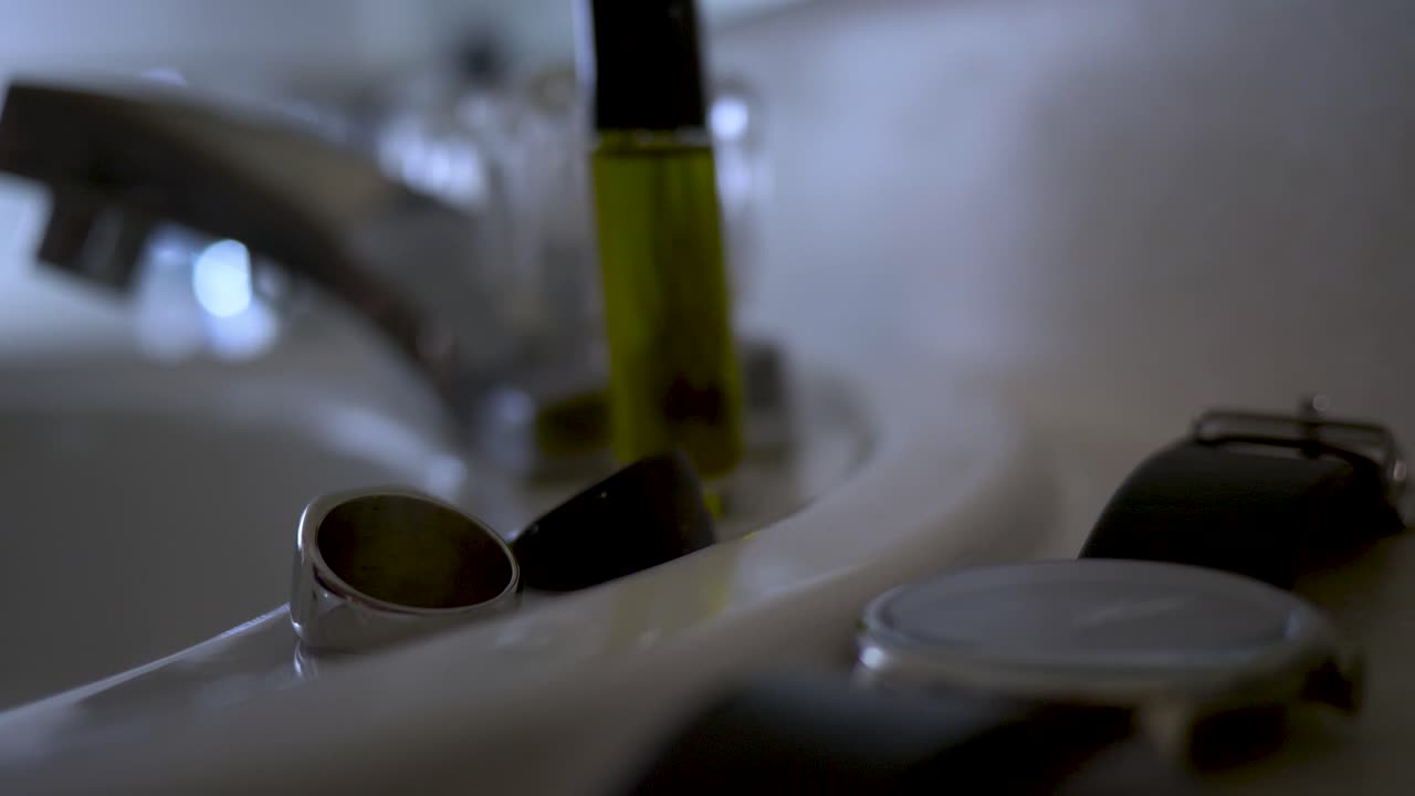 욕실 세면대에 있는 남성용 시계와 반지