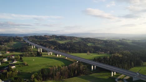 Aerial-View-of-Highway-in-Stunning-Mountains-Scenery-at-Sunset