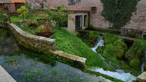 Agua-Que-Fluye-A-Través-De-Un-Exuberante-Follaje-Y-Rocas-Cubiertas-De-Musgo-En-El-Pueblo-Italiano-De-Rasiglia-En-Umbría,-Italia