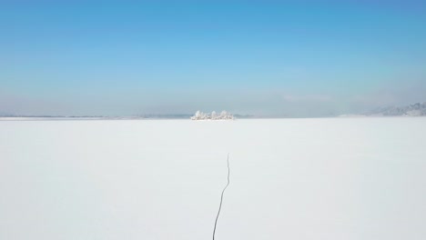 drone above vast snow-filled landscape in birds island, poland during winter