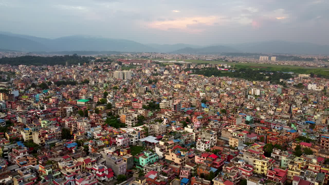 Cinematic zoom of houses with international airport in the background in Kathmandu, Nepal