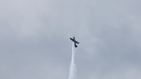 stunt plane executes maneuvers with smoke trails