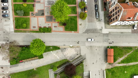 Cars-driving-on-road-in-old-town-of-polish-city-during-sunny-day