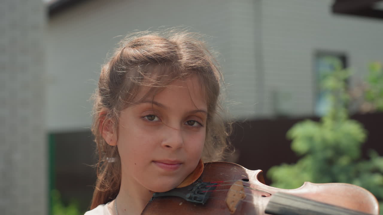 Outdoor Violin Session In Sunlight, Focused Girl Practicing Violin Outside Cheerful Atmosphere, Caucasian Girl Meticulously Playing Violin Outdoors On Her Backyard Porch Under Sunlight