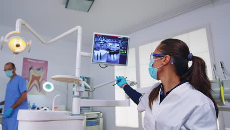 dentistry doctor talking about surgery showing x-ray on monitor