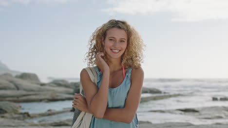 portret van een mooie blonde gelukkige vrouw die op het strand lacht en haar aanraakt