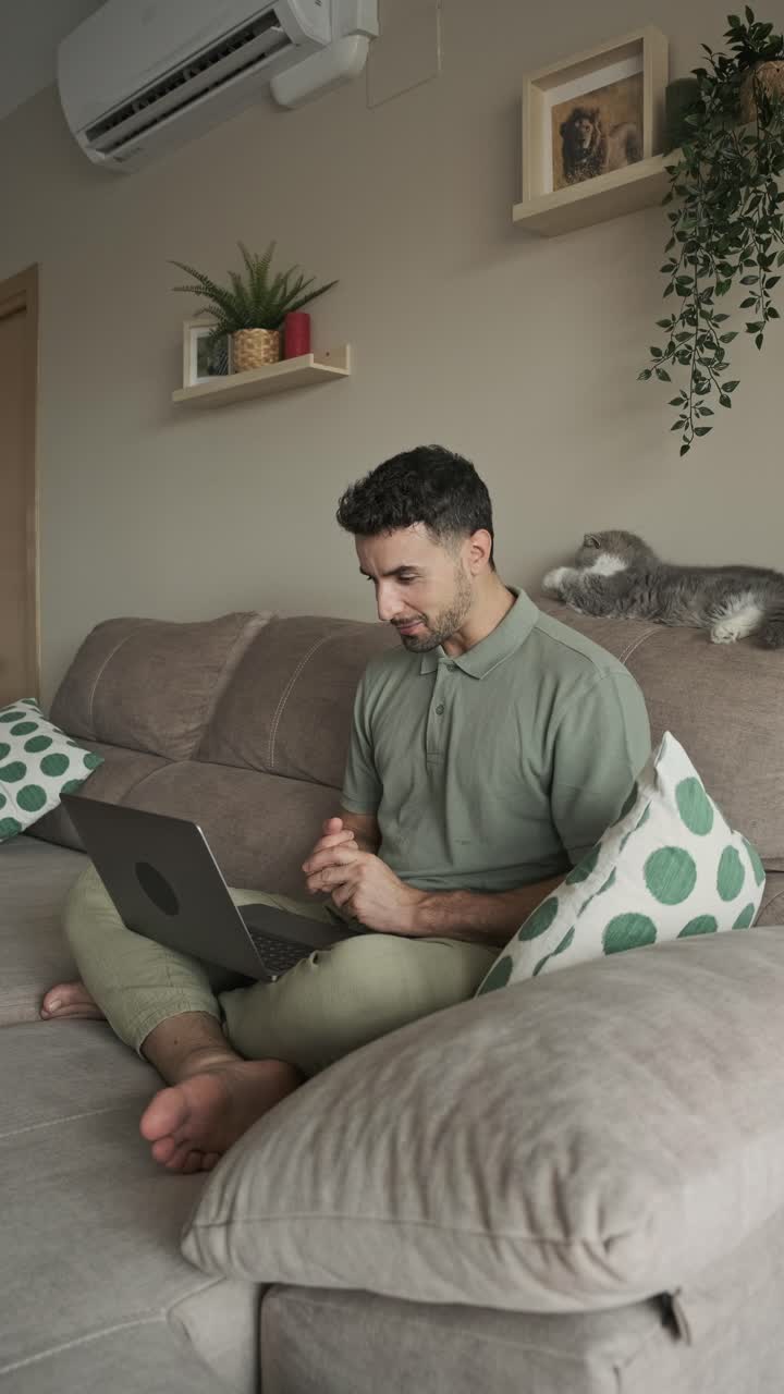 Man on a video call with a cat on the couch