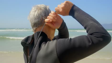 side view of active senior caucasian male surfer wearing wet suit on the beach 4k