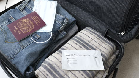 slow zoom into luggage including coronavirus testing kit and face mask