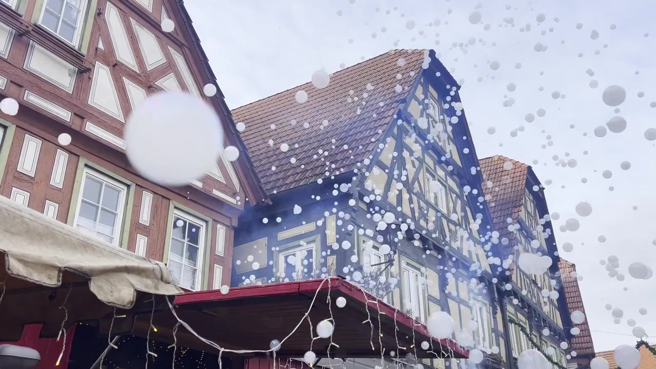 Bolle di sapone fluttuanti davanti a tradizionali edifici a graticcio a Besigheim durante il giorno. Filmato della città storica con dettagli architettonici e riflessi di bolle in movimento.