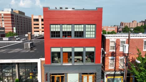 rising aerial shot of modern, industrial style building in small city setting