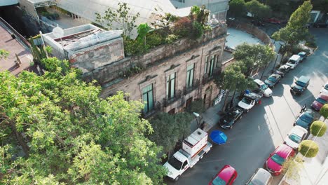 a close aerial view of parked vehicles on the roadside and vehicles passing by in a commercial area