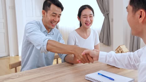 male real estate broker shaking hands with new property owners