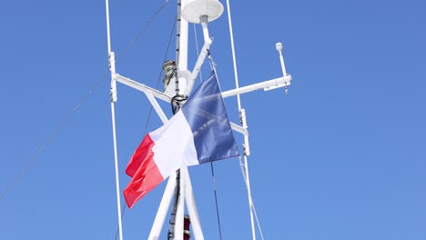 french flag waving on a ship's mast