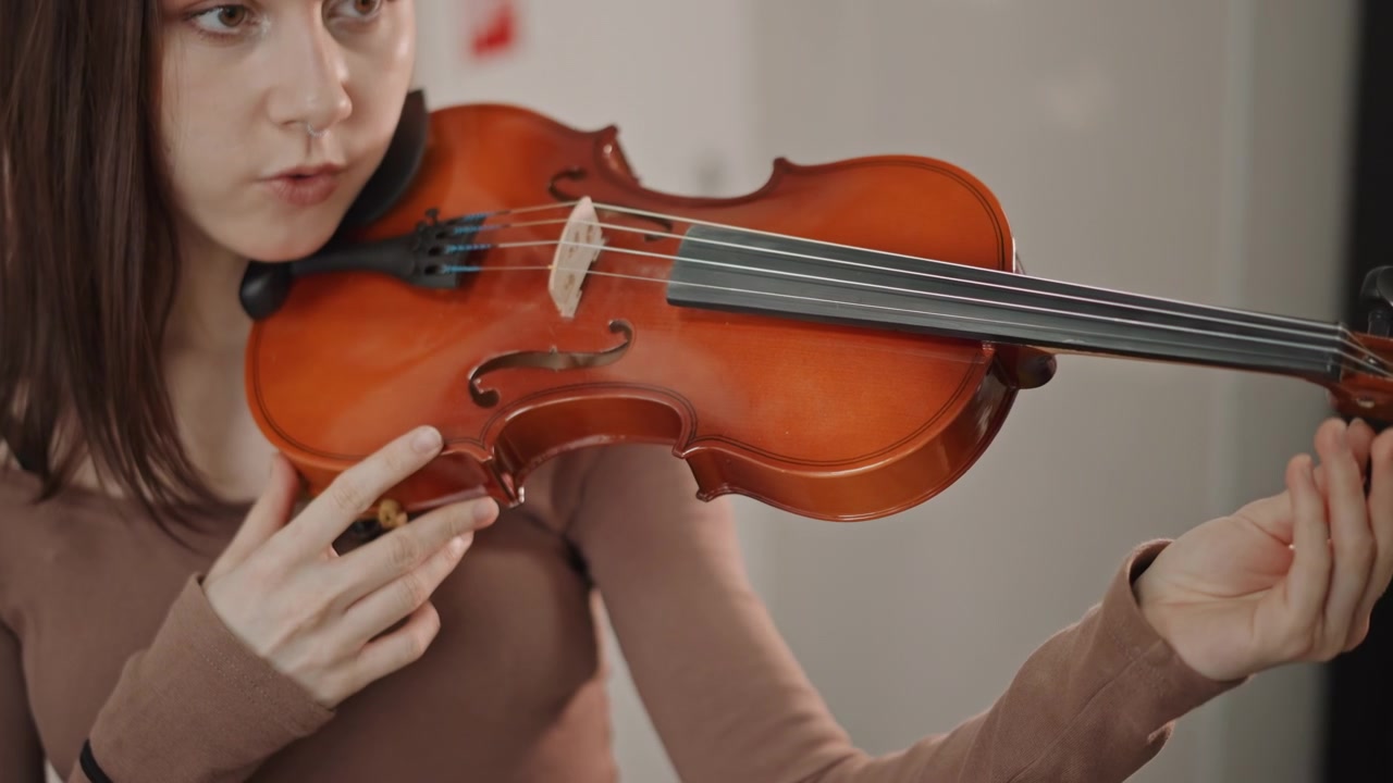 Estudante configura cuidadosamente o instrumento. Estudante focado organiza cuidadosamente o violino para sessões de prática. Músico aspirante arruma meticulosamente o violino com a assistência de orientação de um treinador