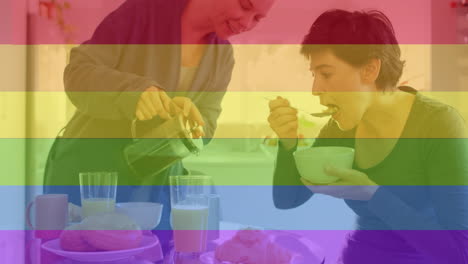 animación de orgullo rayas de arco iris sobre feliz pareja de lesbianas caucásicas tomando café y desayuno
