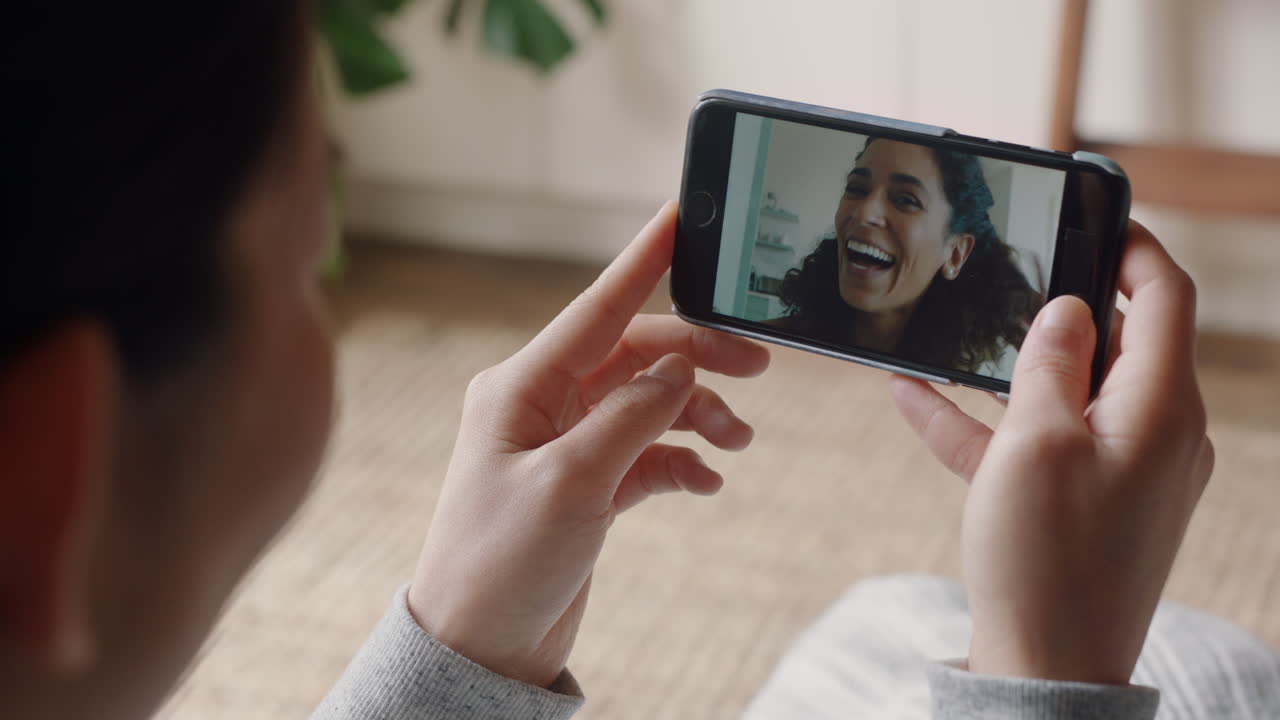mujer joven teniendo video chat usando teléfono inteligente en casa hablando con un amigo mostrando peinado compartiendo estilo de vida disfrutando de la comunicación en línea