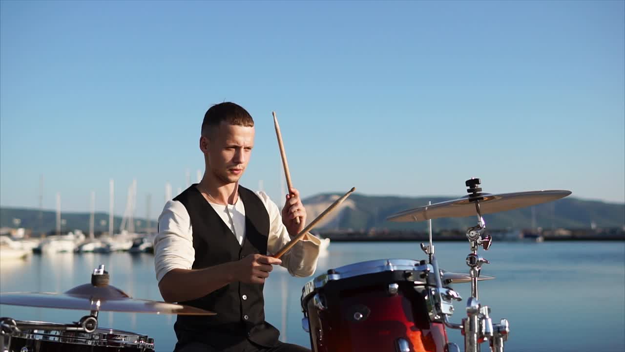 Drummer Playing Drums at a Harbor