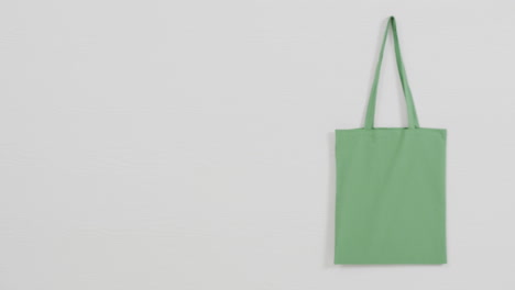 primer plano de la bolsa verde sobre fondo blanco, espacio de copia, cámara lenta