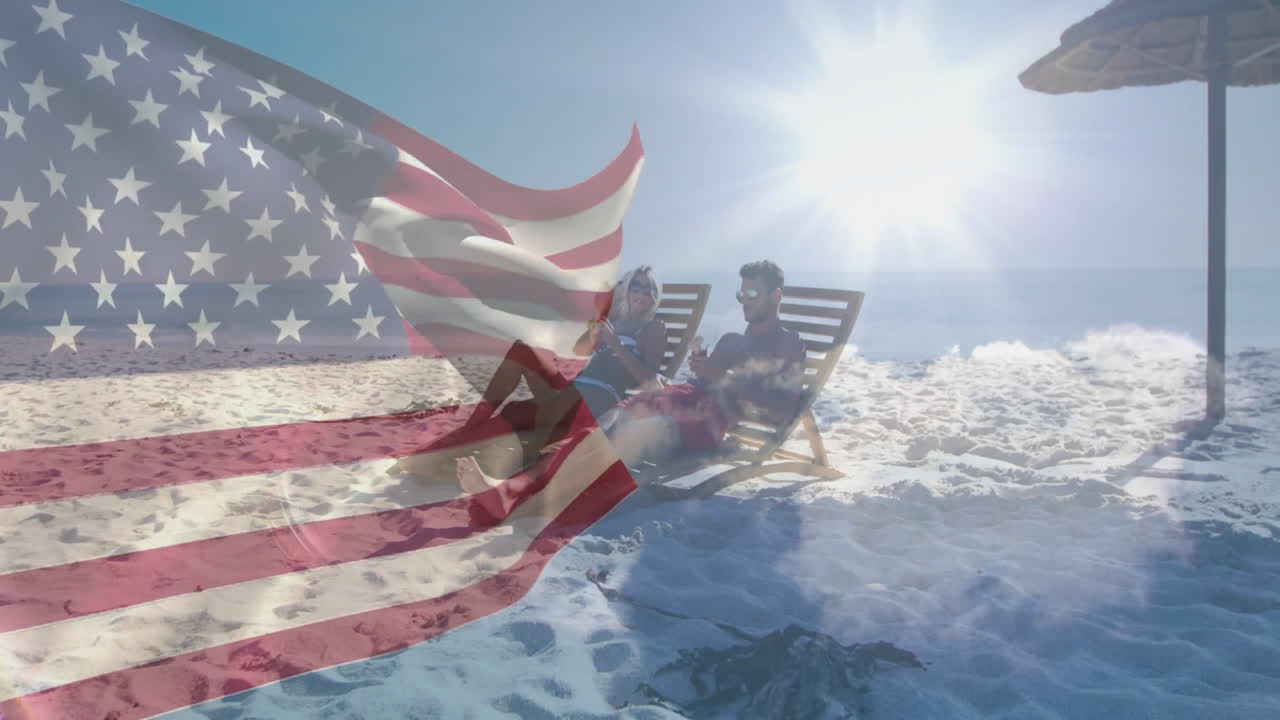 Waving American flag over people relaxing with umbrella on sunny beach
