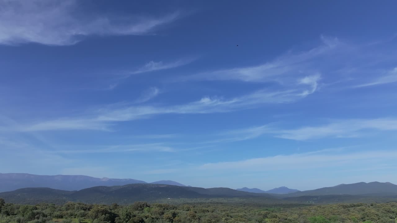 vuelo con un avión no tripulado en un hermoso paisaje en un valle con sus montañas visualizando el impresionante cielo azul con nubes suaves rejas llamadas nubes cirrus en una tarde de primavera