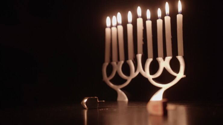 Dreidel Spinning and Menorah Candles Glowing for Hanukkah