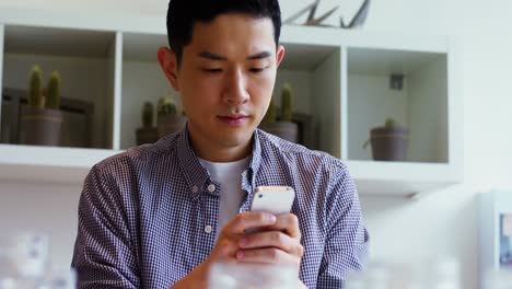 Man-using-mobile-phone-at-his-desk