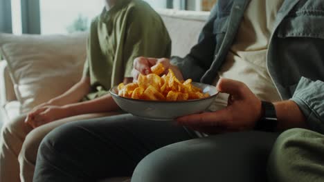 family relaxing on the couch with chips