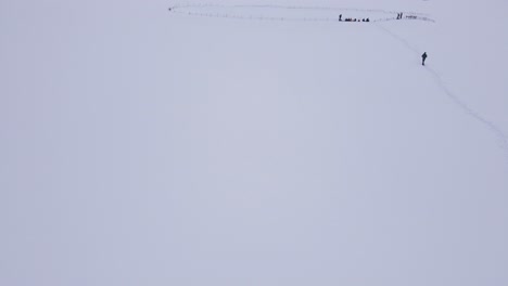 aerial drone shot flying over mountain landscape covered in white snow
